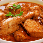 Creamy Saffron Chicken Korma garnished with almonds and saffron strands.
