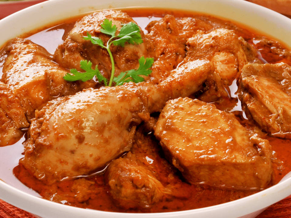 Creamy Saffron Chicken Korma garnished with almonds and saffron strands.