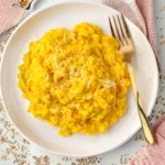 Finished saffron risotto with Parmesan garnished with fresh herbs